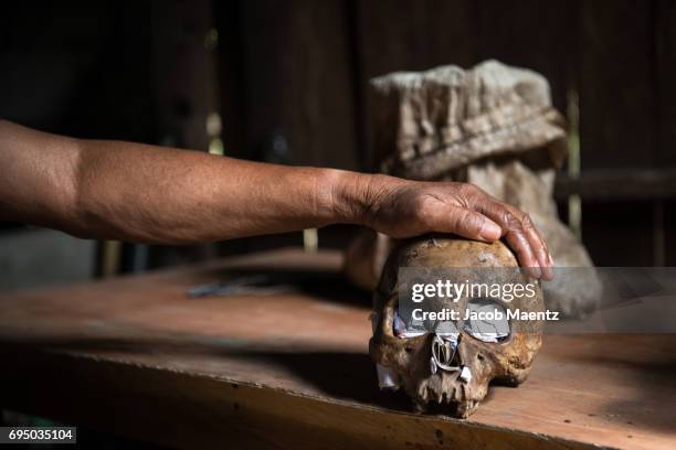 a sorcerer in siquijor island places his hand on a human skull which he uses to cast spells on people. - island of siquijor stock pictures, royalty-free photos & images