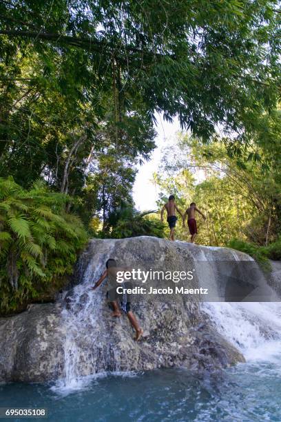 boys playing in cambugahay falls, siquijor. - siquijor islands stock pictures, royalty-free photos & images