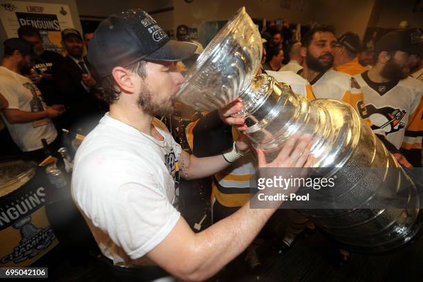 Sidney Crosby of the Pittsburgh Penguins drinks out of the Stanley Cup in the locker room after Game Six of the 2017 NHL Stanley Cup Final at the...