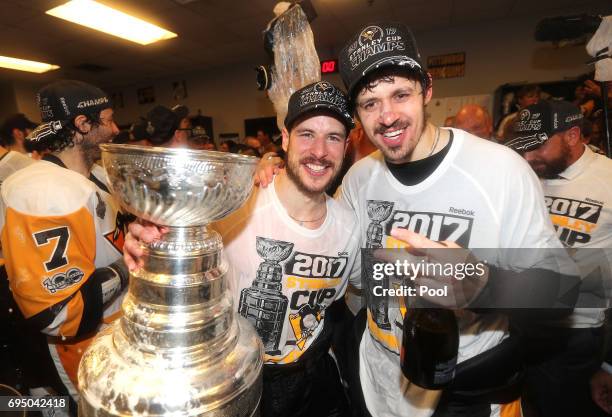 Sidney Crosby and Evgeni Malkin of the Pittsburgh Penguins celebrate with the Stanley Cup in the locker room after Game Six of the 2017 NHL Stanley...