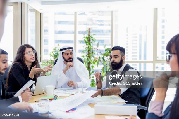 arab business executive chairing an important business meeting - qatar business stock pictures, royalty-free photos & images