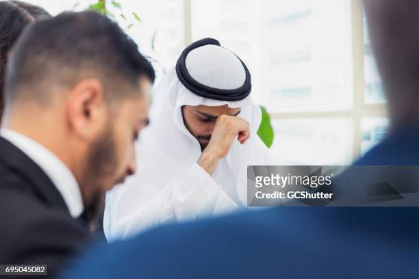 hombre de negocios árabe frustrado y cansado durante una reunión corporativa - gulf countries fotografías e imágenes de stock