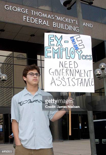 Osme Garcia holds a sign in front of the Mickey Leeland Federal Building January 28, 2002 in Houston, TX. Garcias mother Sonia was laid-off from...