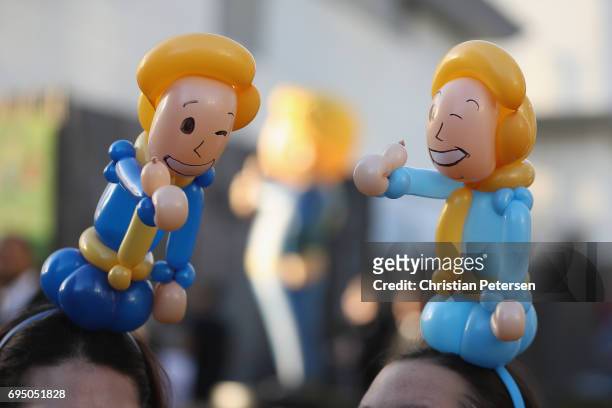 Game enthusiasts wearing 'Vault Boy' balloon hats mingle during the Bethesda E3 conference at the LA Center Studios on June 11, 2017 in Los Angeles,...