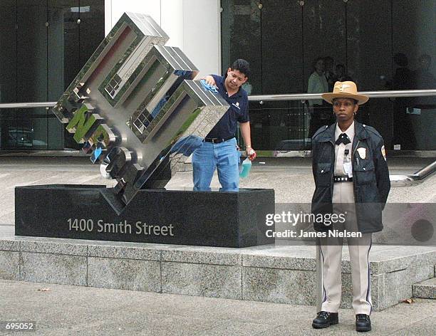 Worker cleans the corporate logo as a security guard stands watch in front of Enrons headquarters January 28, 2002 in Houston, TX. Rev. Jesse Jackson...