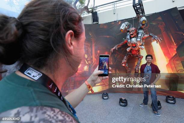 David Sanchez of Mexico City, Mexico poses for a photograph under a 'Doom' statue at the Bethesda E3 conference at the LA Center Studios on June 11,...