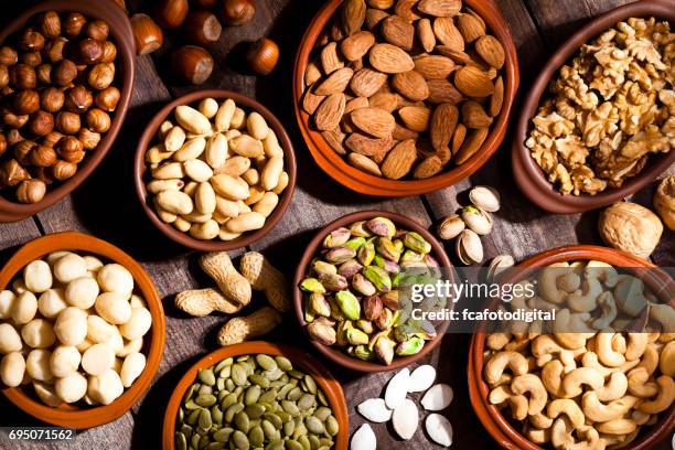 nuts assortment on rustic wood table. - cashews stock pictures, royalty-free photos & images