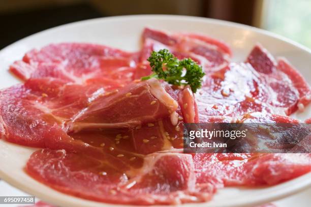 a plate of freshness thin slices raw pork - iberian stockfoto's en -beelden