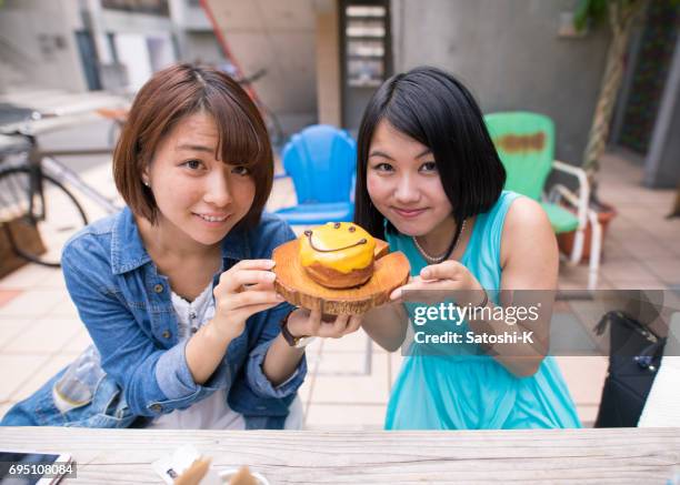 smiling girls and doughnut - harajuku girls stock pictures, royalty-free photos & images