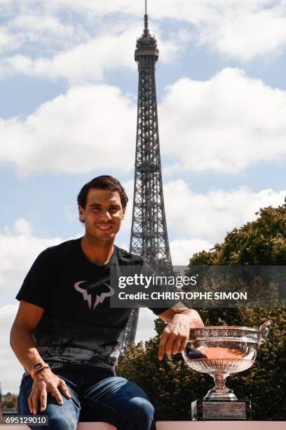 Spain's Rafael Nadal poses with the winner's trophy a day after he won the men's Roland Garros 2017 French Open on June 12, 2017 in Paris, with the...