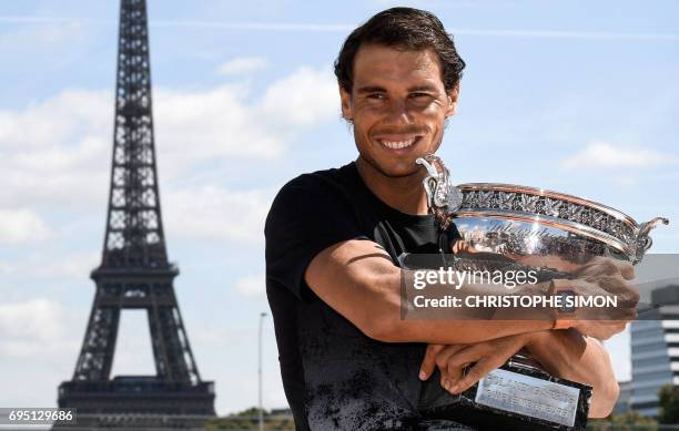 Spain's Rafael Nadal poses with the winner's trophy a day after he won the men's Roland Garros 2017 French Open on June 12, 2017 in Paris, with the...