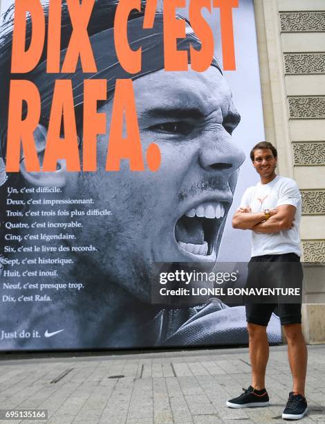 Spain's Rafael Nadal poses by a poster reading "Ten It's Rafa", refering to his tenth win at the French Tennis Open, during a promotional event at...