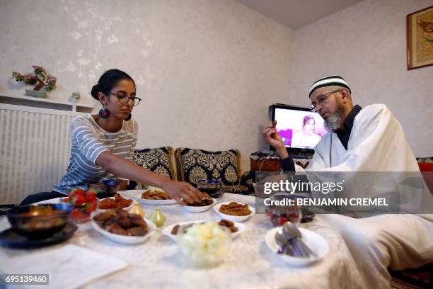 French national Mbirik and his daughter Asmaa break their fast during the Islamic holy month of Ramadan in Les Ulis, southwest of Paris, on June 11...