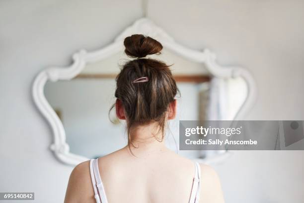 young woman looking in the mirror - preocupación por el cuerpo fotografías e imágenes de stock