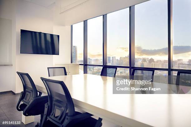 meeting room with view of cityscape sunset - konferenzraum stock-fotos und bilder