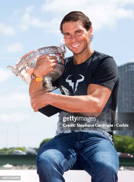 Rafael Nadal of Spain poses with the winner's trophy next to the Eiffel Tower and the Statue of Liberty Monument during a photocall to celebrate his...