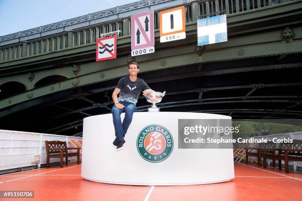 Rafael Nadal of Spain poses with the winner's trophy during a photocall to celebrate his record breaking 10th French Open title on the Seine River on...