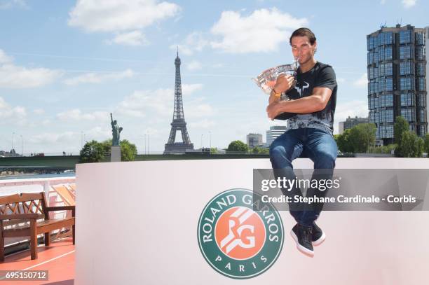 Rafael Nadal of Spain poses with the winner's trophy next to the Eiffel Tower and the Statue of Liberty Monument during a photocall to celebrate his...