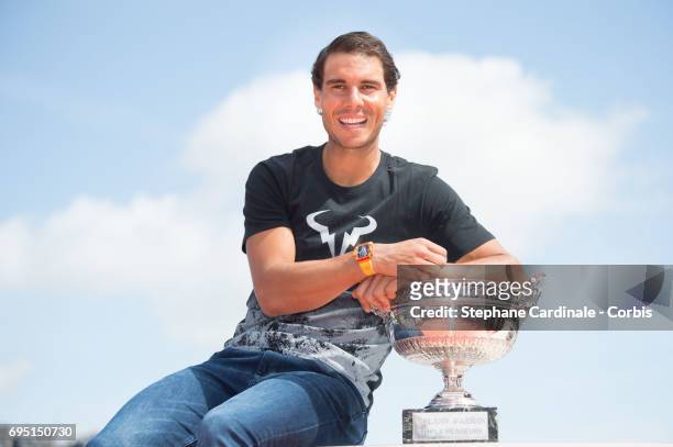 Rafael Nadal of Spain poses with the winner's trophy during a photocall to celebrate his record breaking 10th French Open title on the Seine River on...