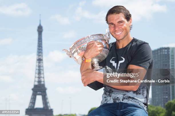 Rafael Nadal of Spain poses with the winner's trophy next to the Eiffel Tower during a photocall to celebrate his record breaking 10th French Open...