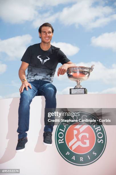 Rafael Nadal of Spain poses with the winner's trophy during a photocall to celebrate his record breaking 10th French Open title on the Seine River on...