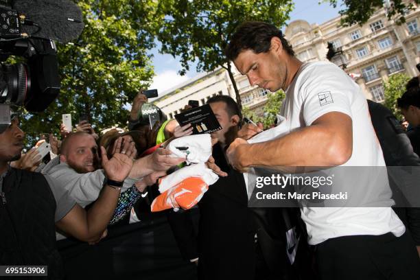 Rafael Nadal signs autographs during a promotional event at the 'Nike Store' on the Champs-Elysees avenue, one day after winning the men's Roland...