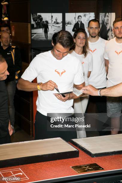 Rafael Nadal signs autographs during a promotional event at the 'Nike Store' on the Champs-Elysees avenue, one day after winning the men's Roland...