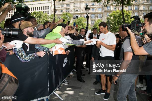 Rafael Nadal signs autographs during a promotional event at the 'Nike Store' on the Champs-Elysees avenue, one day after winning the men's Roland...