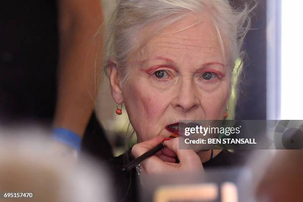 British designer Vivienne Westwood is reflected in a mirror as she has her make-up applied backstage ahead of a her catwalk show at London Fashion...