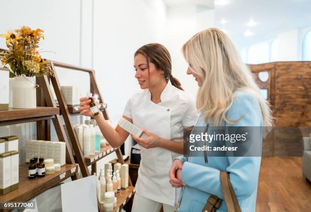donna che fa shopping per prodotti di bellezza in un negozio - prodotti di bellezza foto e immagini stock