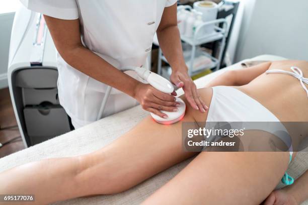 woman getting laser treatment at the spa - cellulite stock pictures, royalty-free photos & images