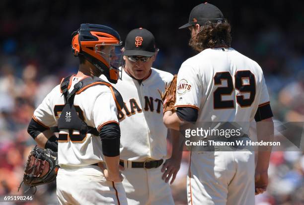 Pitching coach Dave Righetti and catcher Buster Posey of the San Francisco Giants comes out to talk with pitcher Jeff Samardzija after Samardzija...