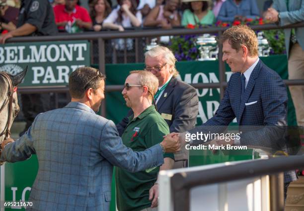 Bobby Flay congratulates trainer H. Graham Motion of the horse Ascend, in the winners circle after the Manhattan Stakes at Belmont Park on June 10,...