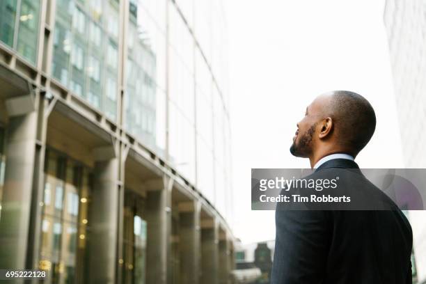 man in suit looking up - businessman in black suit photos et images de collection