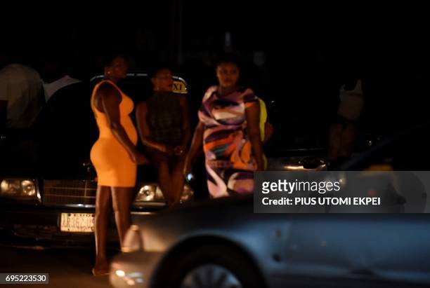 Prostitutes stand on the street in Benin City, capital of Edo State, southern Nigeria, on March 29, 2017. In Benin City, Nigeria's capital of illegal...