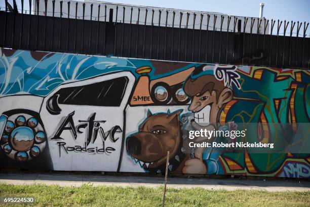 Factory wall with painted graffiti can be seen May 21, 2017 in the Los Angeles Police Department's 77th Division neighborhood in Los Angeles,...