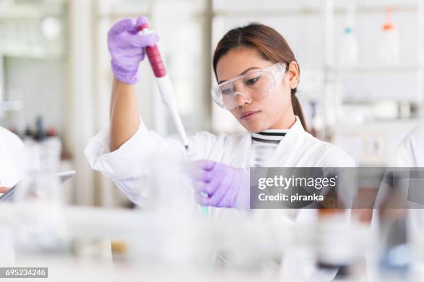 wetenschapper pipetteren - medisch specimen stockfoto's en -beelden