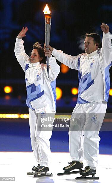 Gold medal speed skaters, Bonnie Blair and Dan Jansen, carry the torch towards the cauldron at the Opening Ceremony of the Salt Lake City Winter...