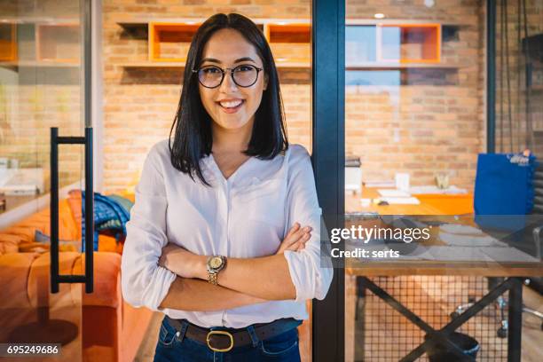 portret van lachende jonge zakenvrouw in kantoor - job glasses stockfoto's en -beelden