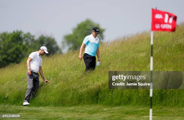 Alexander Noren of Sweden and Martin Kaymer of Germany look for a ball on the 17th hole during a practice round prior to the 2017 U.S. Open at Erin...