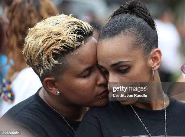 Angel Ayala and Carla Montanez hug as they mourn the loss of their best friend in the mass shooting at the Pulse gay nightclub as people gather...