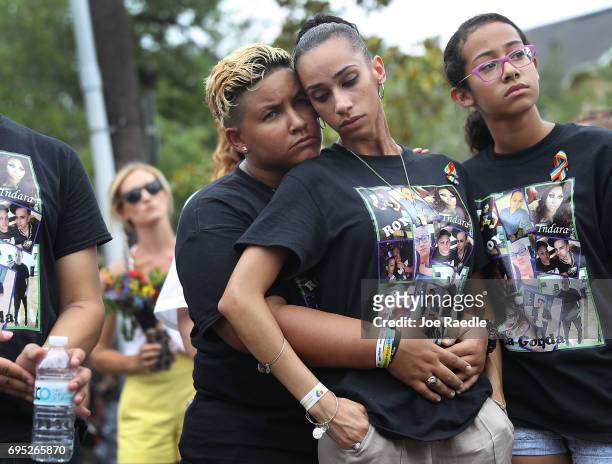 Angel Ayala and Carla Montanez mourn the loss of their best friend in the mass shooting at the Pulse gay nightclub as people gather together outside...