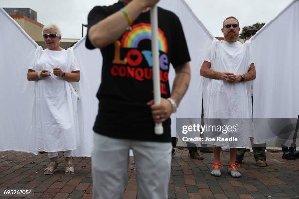 Mourners dressed as "guardian angels" attend the one-year anniversary memorial service for victims of the mass shooting at the Pulse gay nightclub on...