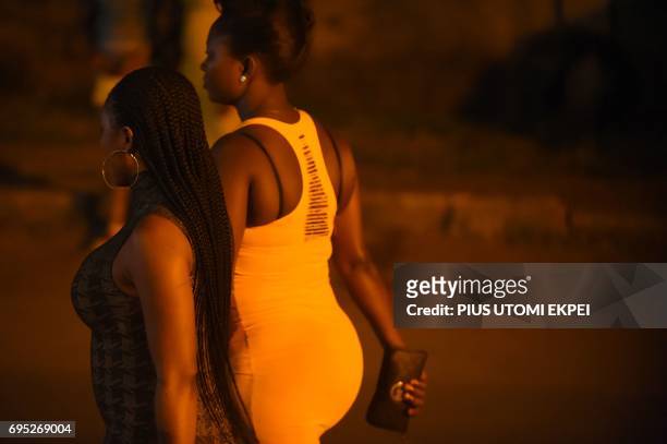 Prostitutes stand walk on the street in Benin City, capital of Edo State, southern Nigeria, on March 29, 2017. In Benin City, Nigeria's capital of...