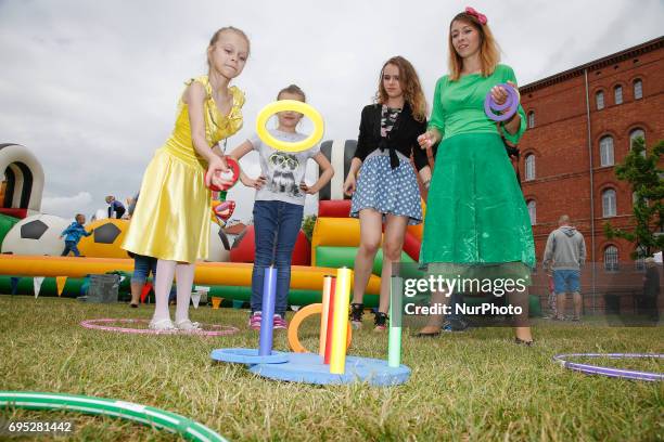 Young girl is seen playing ring toss during an amusement fare on the Mill Island on 10 June, 2017.