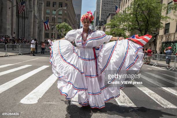 Woman dances along Fifth Avenue during the NYC's 60th annual Puerto Rico Day parade led by mayor Bill de Blasio on June 11, 2017 in New York City.