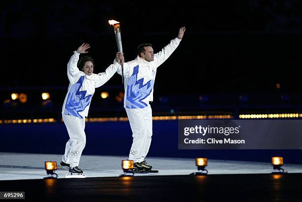 Gold medalists, Bonnie Blair and Dan Jansen, skate with the Olympic torch during the Opening Ceremony of the Salt Lake City Winter Olympic Games at...