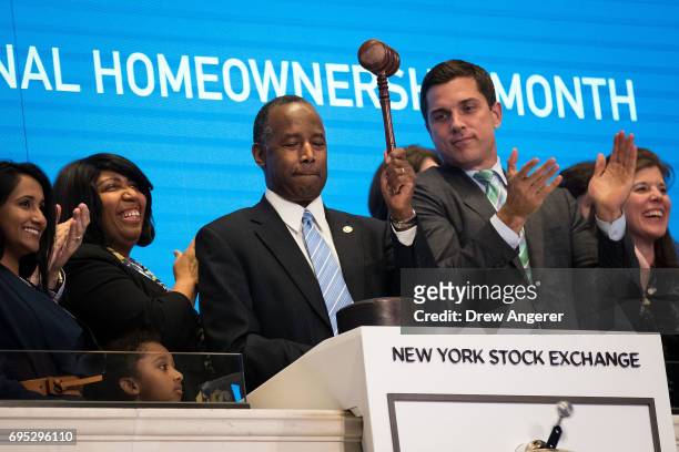 Secretary of Housing and Urban Development Ben Carson , flanked by wife Candy Carson and Thomas Farley, president of the NYSE, bangs the gavel after...