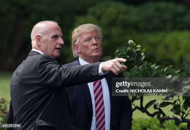 President Donald Trump listens to Director of Oval Office Operations Keith Schiller as he prepares to leave after welcoming the Clemson Tigers, the...