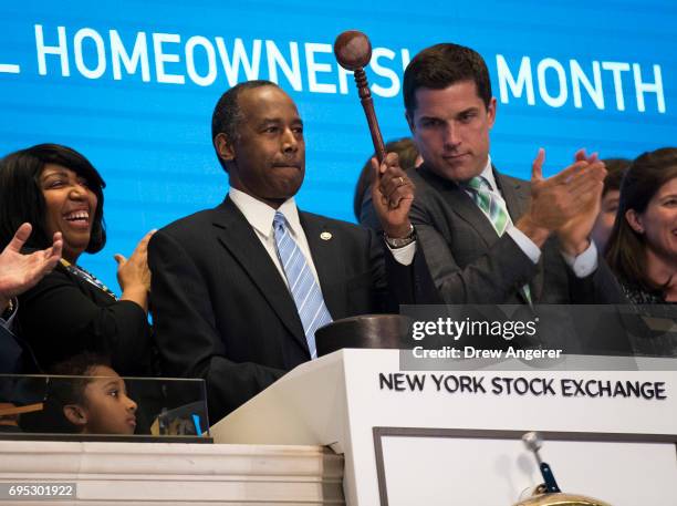 Secretary of Housing and Urban Development Ben Carson , flanked by wife Candy Carson and Thomas Farley, president of the NYSE, bangs the gavel after...